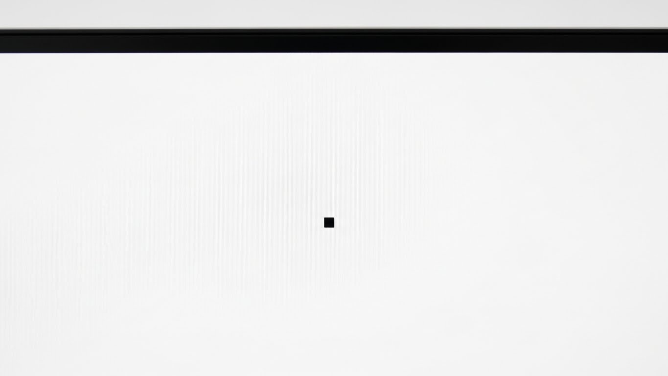 Close-up photograph showing dead pixel on monitor with white screen background for testing